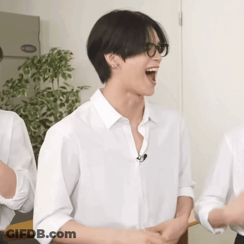 A Man Wearing Glasses And A White Shirt Laughs With His Mouth Open GIF