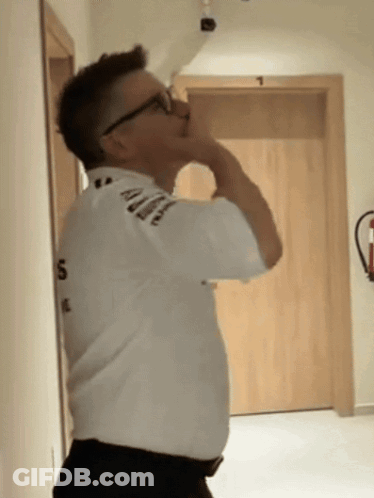 A Man Wearing Glasses And A White Shirt With The Number 5 On It GIF