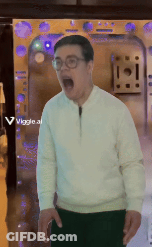 A Man Wearing Glasses And A White Sweater Is Standing In Front Of A Door With A Viggle.ai Sticker On It GIF