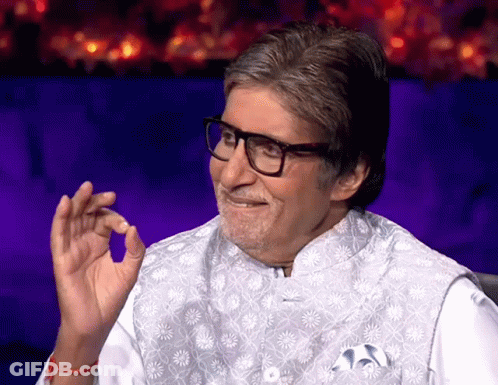 A Man Wearing Glasses And A White Vest Smiles GIF