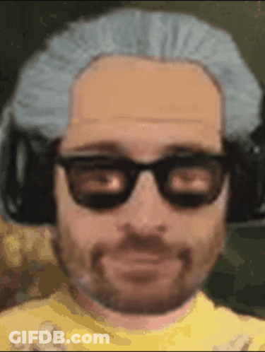 A Man Wearing Glasses And A Wig Is Smiling GIF