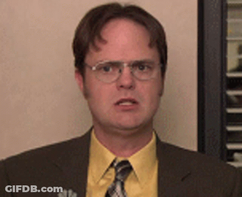 A Man Wearing Glasses And A Yellow Shirt Is Making A Funny Face GIF