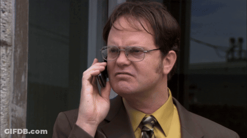A Man Wearing Glasses And A Yellow Shirt Talks On A Cell Phone GIF