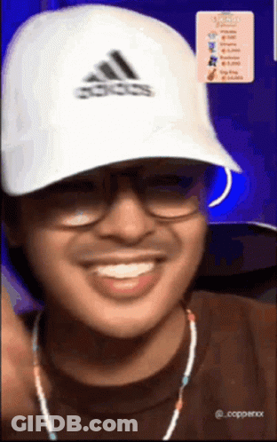 A Man Wearing Glasses And An Adidas Hat Smiles GIF