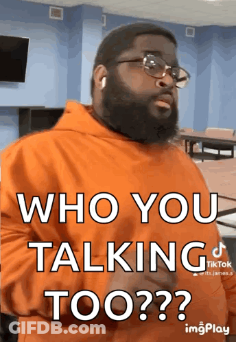 A Man Wearing Glasses And An Orange Hoodie Says Who You Talking Too ? GIF