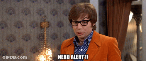 A Man Wearing Glasses And An Orange Suit Says Nerd Alert GIF