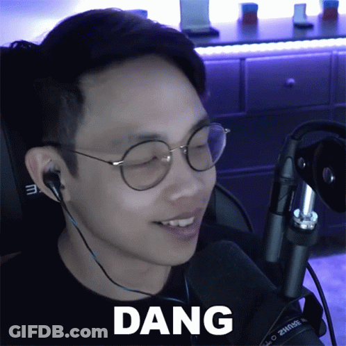 A Man Wearing Glasses And Ear Buds Says Dang GIF
