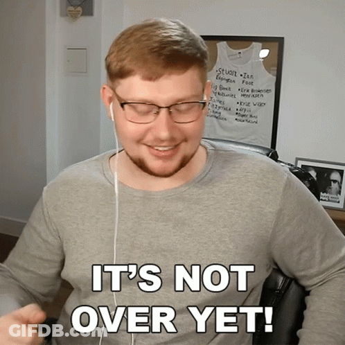 A Man Wearing Glasses And Ear Buds Says " It 'S Not Over Yet " GIF