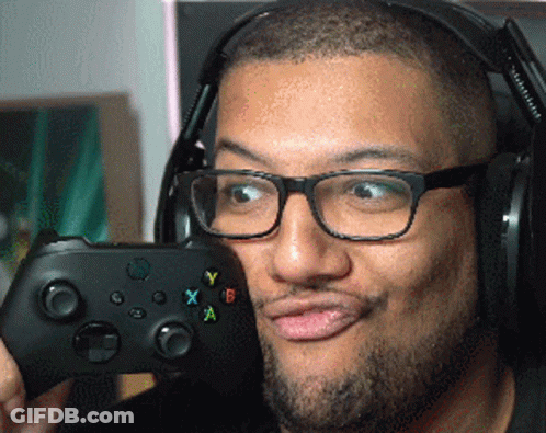 A Man Wearing Glasses And Headphones Is Holding A Controller GIF