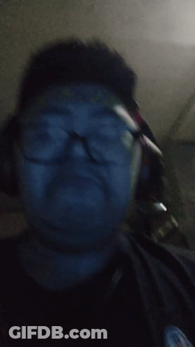 A Man Wearing Glasses And Headphones Is Looking At The Camera GIF