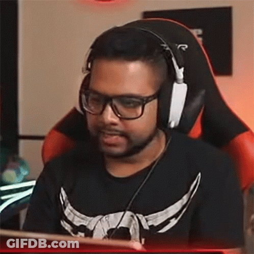 A Man Wearing Glasses And Headphones Is Sitting In A Chair . GIF