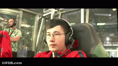 A Man Wearing Glasses And Headphones Is Sitting In A Chair That Says Akracing GIF