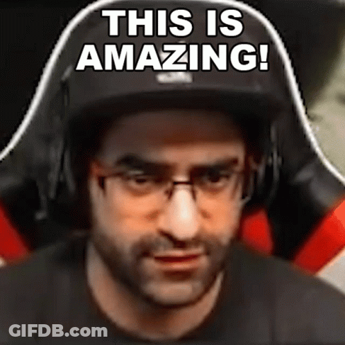 A Man Wearing Glasses And Headphones Is Sitting In A Gaming Chair And Says `` This Is Amazing ! '' GIF