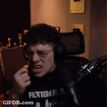 A Man Wearing Glasses And Headphones Is Sitting In Front Of A Microphone And Making A Funny Face . GIF