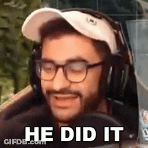 A Man Wearing Glasses And Headphones Is Sitting In Front Of A Microphone And Smiling . GIF