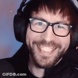 A Man Wearing Glasses And Headphones Is Smiling . GIF