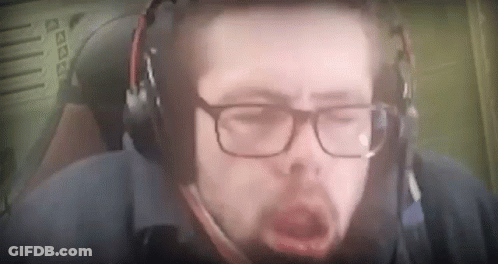 A Man Wearing Glasses And Headphones Is Yawning While Sitting In A Chair . GIF