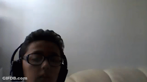 A Man Wearing Glasses And Headphones Looks At The Camera GIF