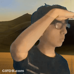 A Man Wearing Glasses Covering His Eyes In Front Of A Desert GIF