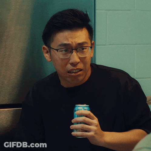 A Man Wearing Glasses Holds A Can Of Soda In His Hand GIF