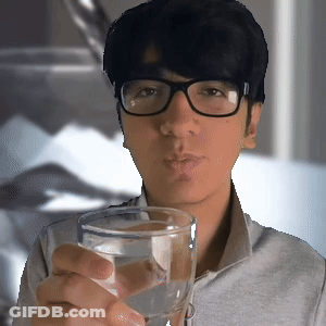 A Man Wearing Glasses Holds A Glass Of Water GIF