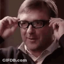 A Man Wearing Glasses Is Adjusting His Glasses . GIF