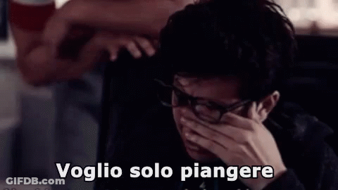 A Man Wearing Glasses Is Crying While Talking On A Phone . GIF
