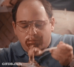 A Man Wearing Glasses Is Eating Spaghetti With A Fork And Spoon . GIF