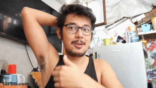 A Man Wearing Glasses Is Giving A Thumbs Up In Front Of A Fridge That Says ' Fresh ' On It GIF