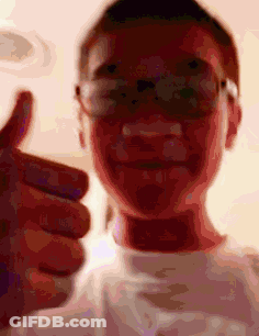 A Man Wearing Glasses Is Giving A Thumbs Up GIF