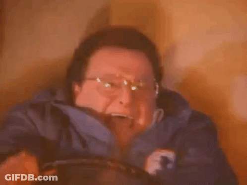 A Man Wearing Glasses Is Holding A Candle In His Hand . GIF