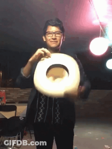 A Man Wearing Glasses Is Holding A Cowboy Hat In His Hand GIF