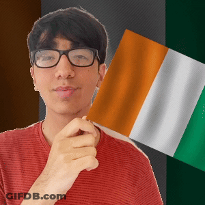 A Man Wearing Glasses Is Holding A Flag In His Hand GIF