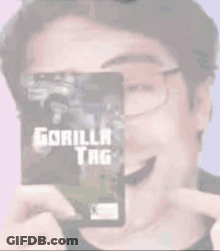 A Man Wearing Glasses Is Holding A Gorilla Tag Card GIF