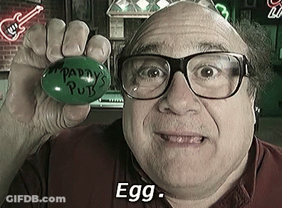 A Man Wearing Glasses Is Holding A Green Egg With The Words `` Paddy 'S Pub '' Written On It . GIF