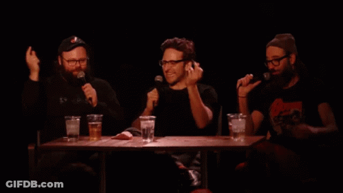 A Man Wearing Glasses Is Holding A Microphone And Making A Funny Face While Saying Snap . GIF