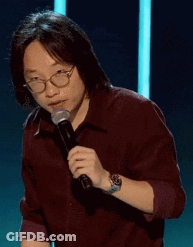 A Man Wearing Glasses Is Holding A Microphone And Says " Good " GIF