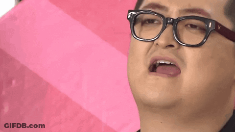 A Man Wearing Glasses Is Holding A Pink Umbrella And Making A Funny Face . GIF