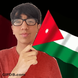 A Man Wearing Glasses Is Holding A Small Flag In Front Of His Face GIF