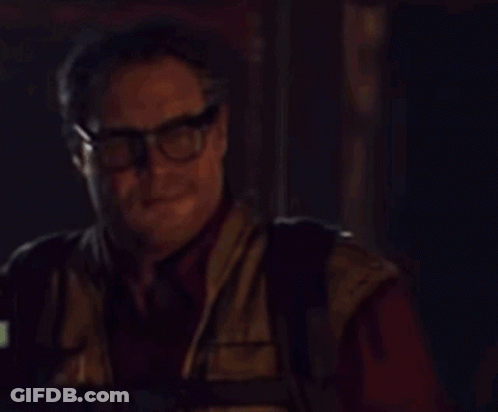 A Man Wearing Glasses Is Holding A Walkie Talkie GIF