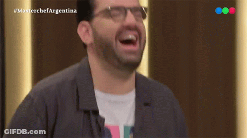 A Man Wearing Glasses Is Laughing In Front Of A Masterchef Argentina Logo GIF