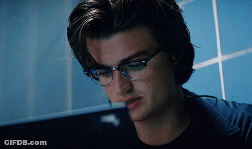A Man Wearing Glasses Is Looking At A Computer Screen GIF