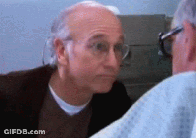 A Man Wearing Glasses Is Looking At Another Man In A Hospital Gown . GIF