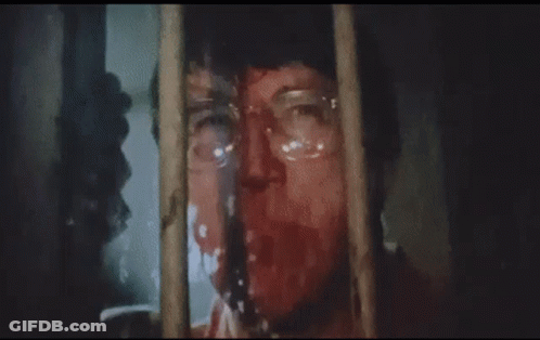 A Man Wearing Glasses Is Looking Through A Window . GIF