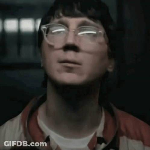 A Man Wearing Glasses Is Looking Up At Something GIF