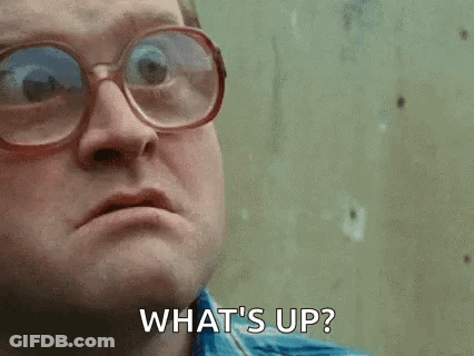 A Man Wearing Glasses Is Making A Face And Saying `` What 'S Up '' . GIF
