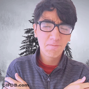 A Man Wearing Glasses Is Making A Face With His Arms Crossed In Front Of A Christmas Tree GIF