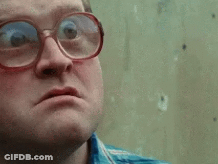A Man Wearing Glasses Is Making A Funny Face And Looking At The Camera . GIF