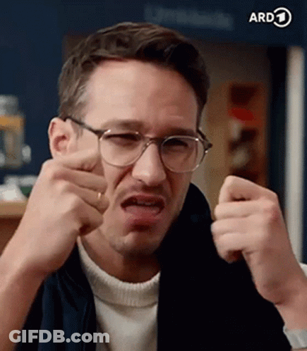 A Man Wearing Glasses Is Making A Funny Face And Making A Funny Face . GIF