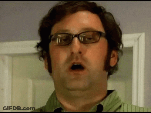 A Man Wearing Glasses Is Making A Funny Face . GIF